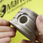 3D printed metal part in front of the Mark3D UK logo